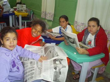 CrianÃ§as fazendo atividade com jornais