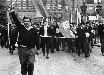 Pessoas marcham com bandeira tcheca suja de sangue
