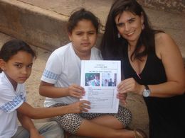 Foto mostra Elizangela e dois alunos com o jornal EscolAção. 