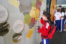 Foto mostra garoto em interação com material da exposição.