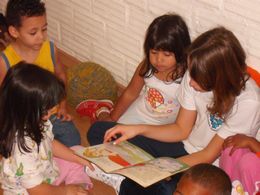 Foto mostra crianças lendo.