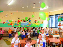 Alunos brincam com balões, na sala de aula.