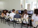 Alunos, de costas, usam computadores