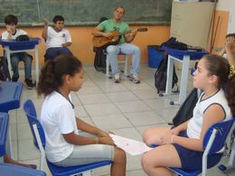 Professor toca violão para alunos na sala de aula