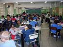 Estudantes e professores durante aula em salão da escola