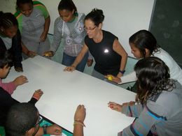 Professora Denise e alunos ao redor de mesa