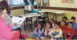Guadalupe lê para alunos na sala de aula