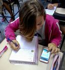 Estudante usa celular na sala de aula