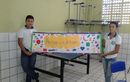 Dois alunos seguram cartaz sobre o tema amizade