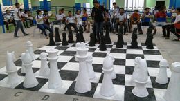 Alunos e peças gigantes de xadrez