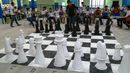 Alunos e peças gigantes de xadrez