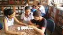 Alunos jogam mancala na biblioteca