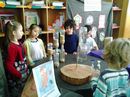 Crianças observam relógios feitos com material reaproveitado